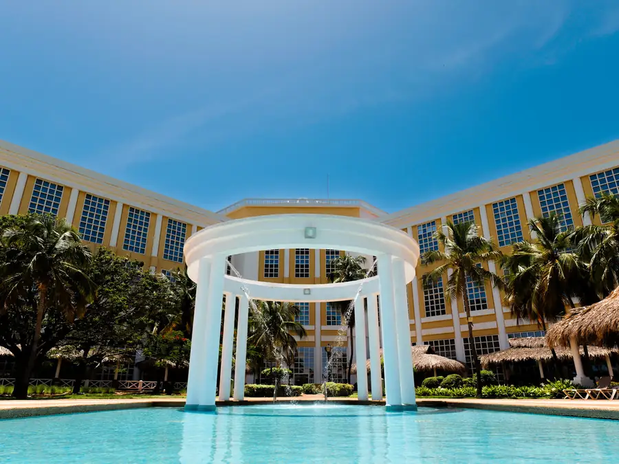 Piscina con pérgola y el hotel al fondo